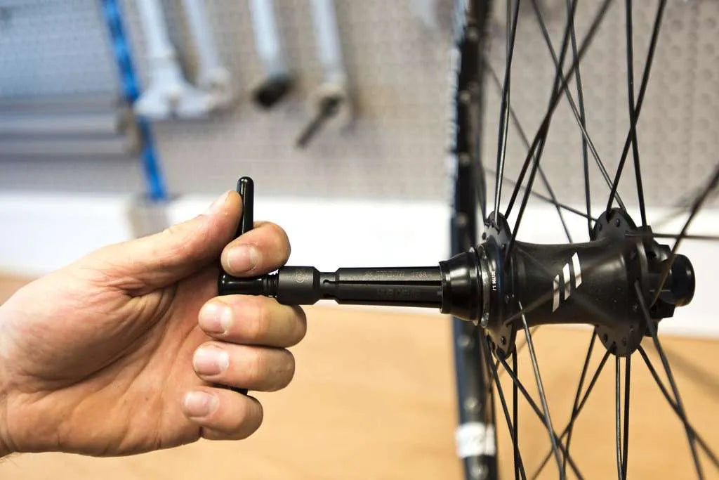 POV angle of someone using a Unior Hub Genie to remove a 20 mm hub end cap