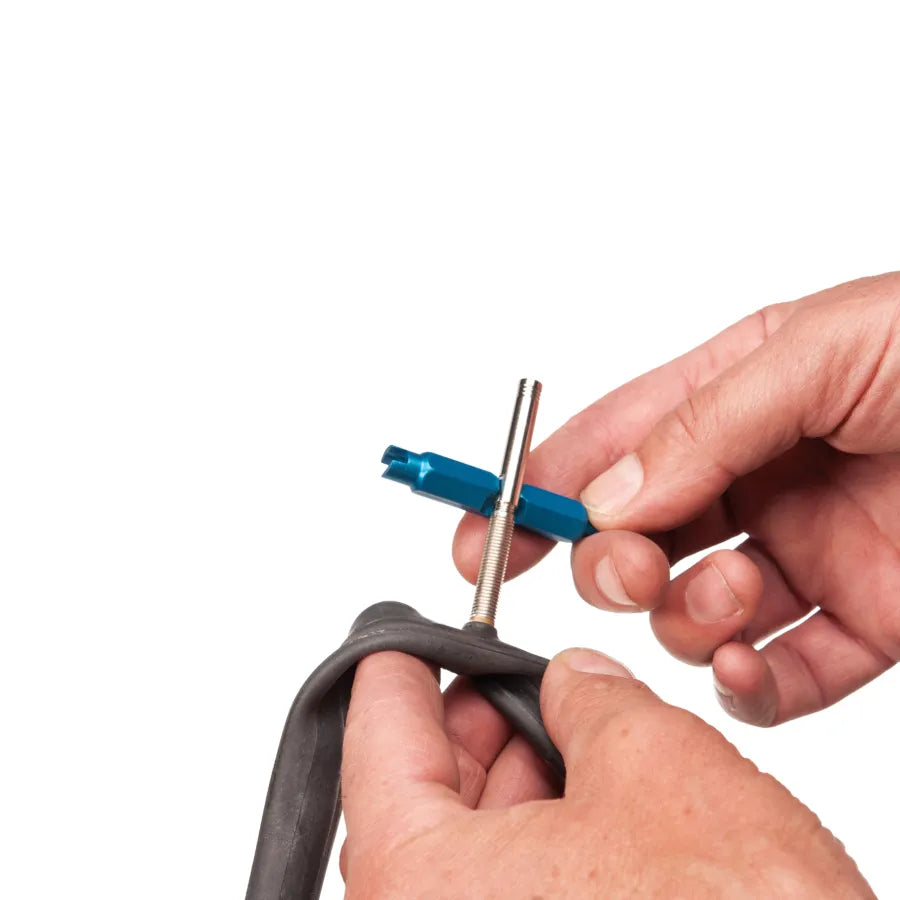 pov of anodised blue Park Tool VC-1 Valve Core Tool being used to install a presta valve extender