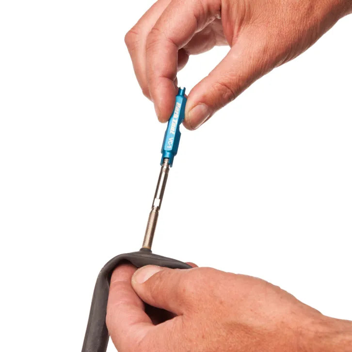 pov of anodised blue Park Tool VC-1 Valve Core Tool being used to install a presta valve extender