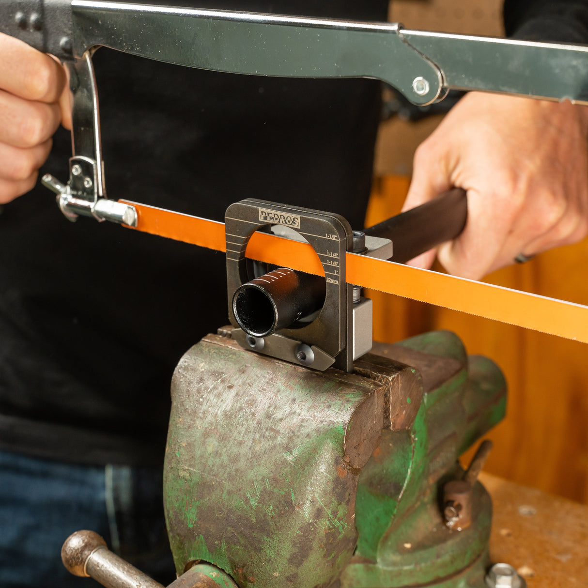 Pedro's Pro Saw Guide being used to cut an aluminium steerer tube with an orange hacksaw blade in an old green vice