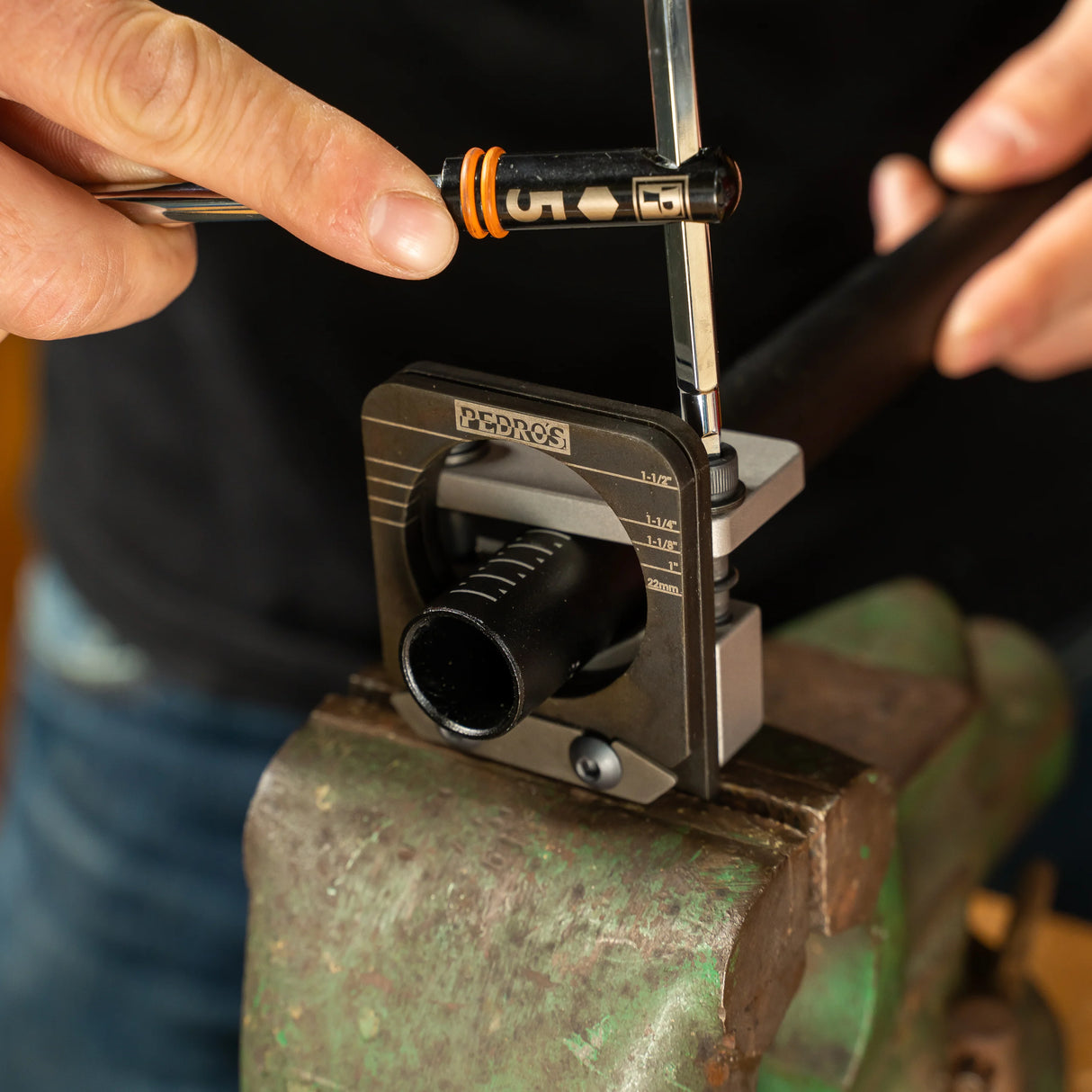 Pedro's Pro Saw Guide being tightened to clamp an aluminium steerer tube with a Pedro's sliding T Handle in old green vice