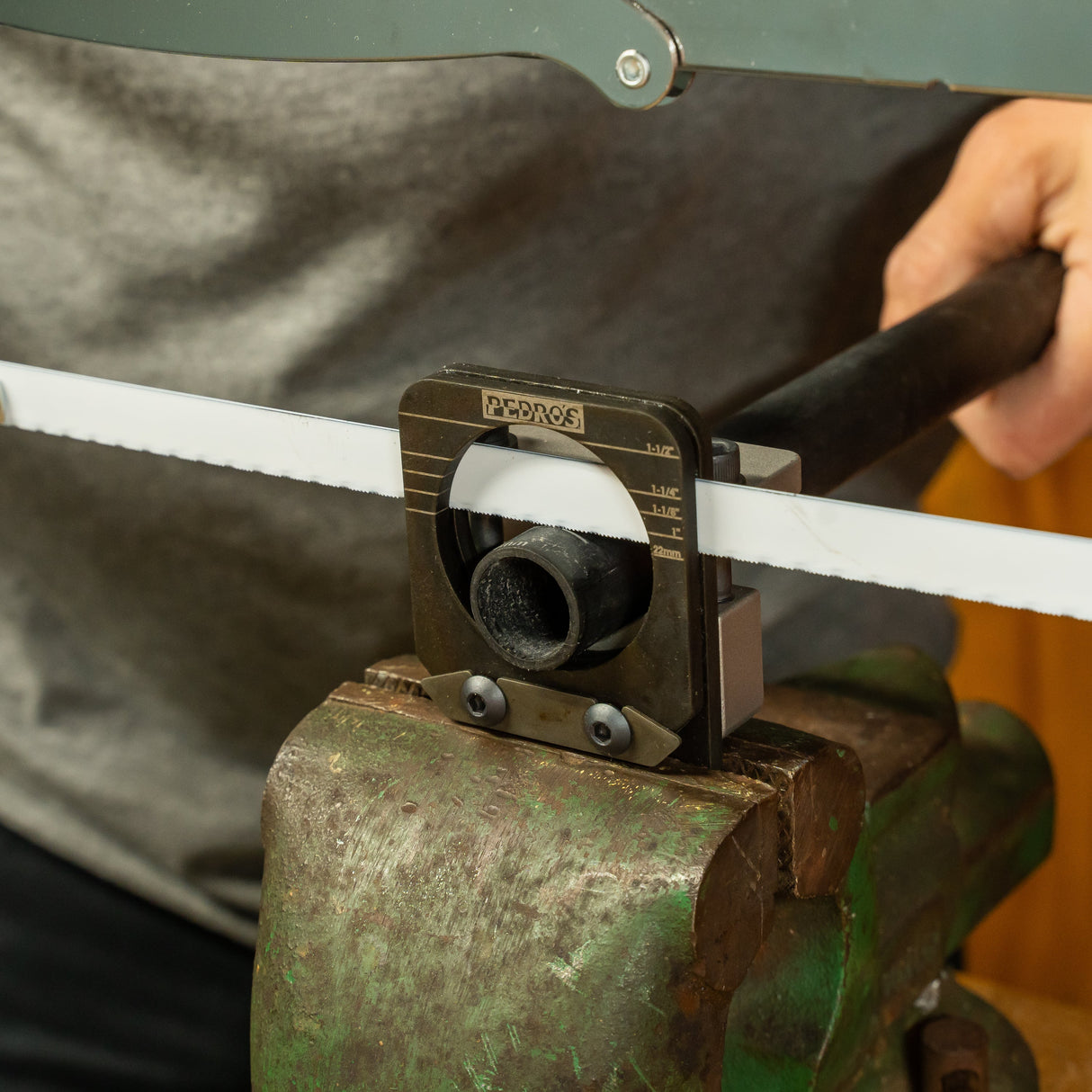 Pedro's Pro Saw Guide being used to cut an aluminium handlebar with a hacksaw blade in an old green vice