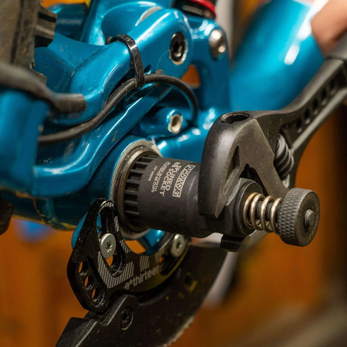 Pedro's Bottom Bracket Socket Holder being used with a Pedrp's Splined BB Socket on a blue mountain bike frame