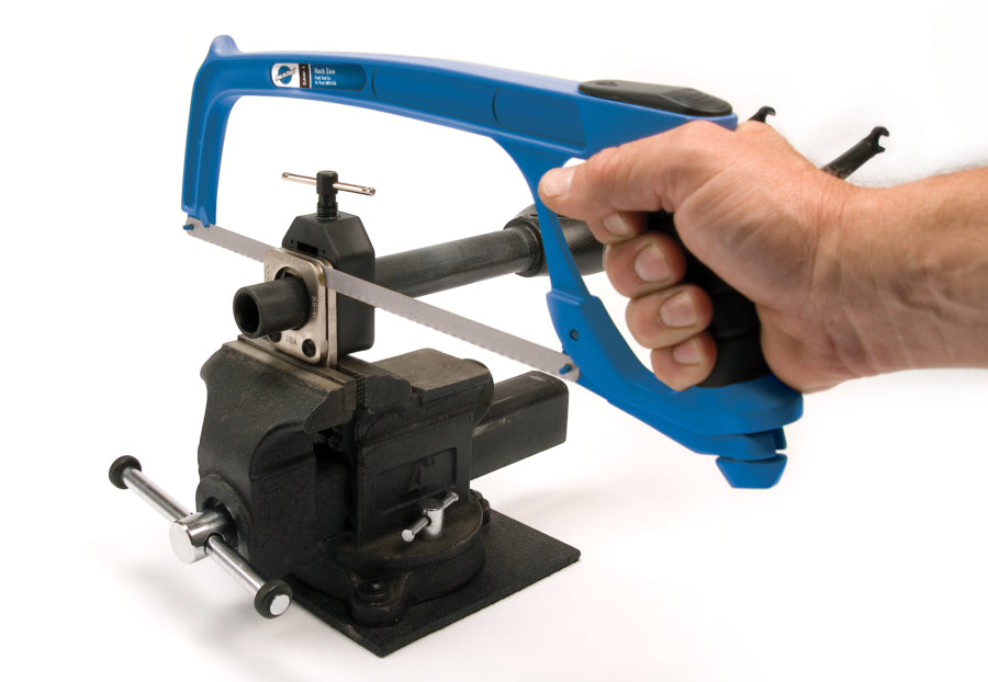 Park tool hacksaw being used with a tube cutting guide in a vise to cut a bicycle steerer tube